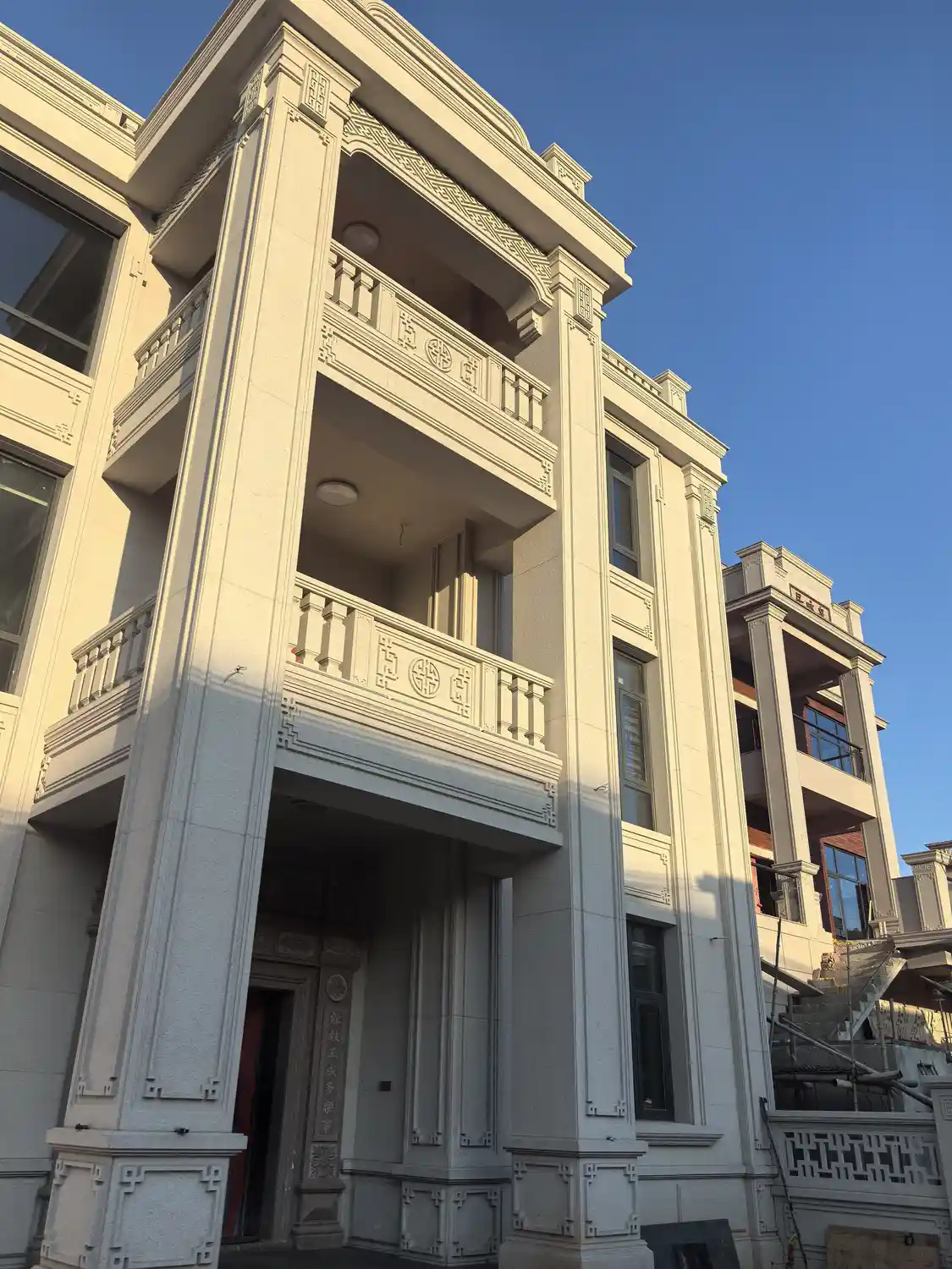Pale exterior entrance surround, columns and balcony details in China