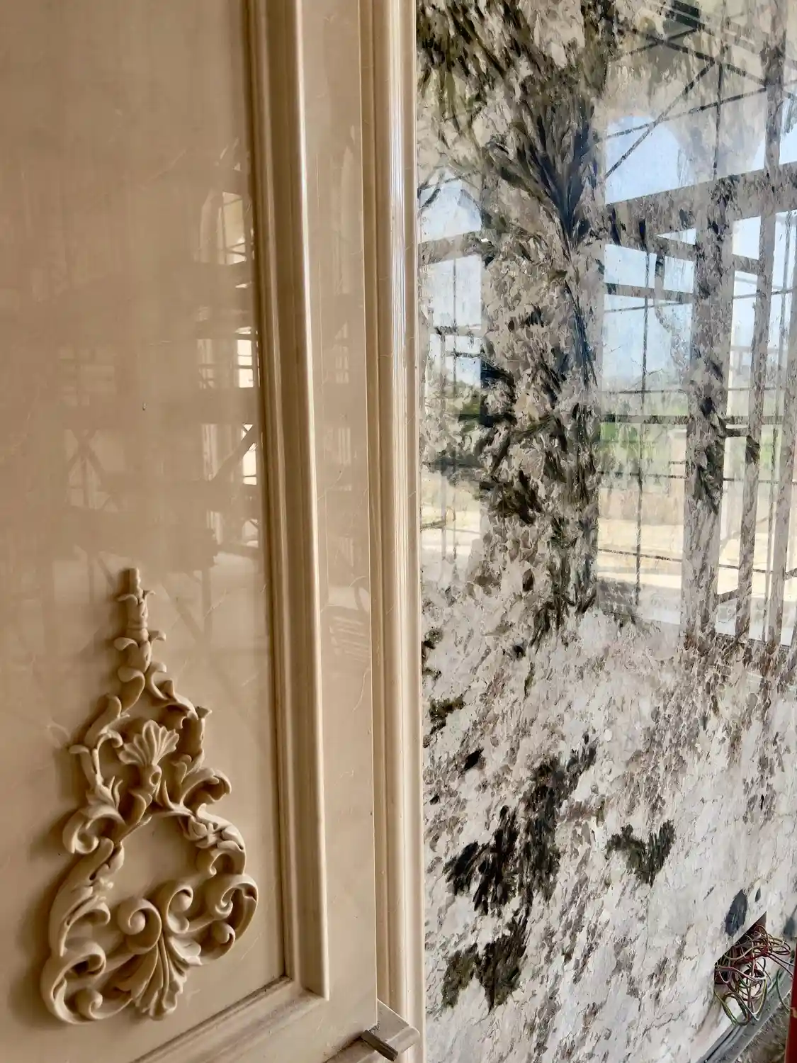 Verde Alpi book-matched green marble wall with carved Crema Marfil ornament